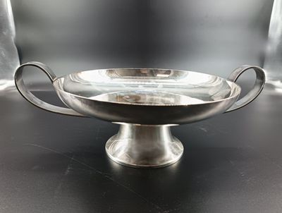 a silver bowl with handles on a black table