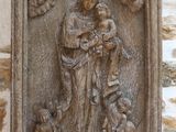 statue d'une femme tenant un enfant sur un mur de pierre