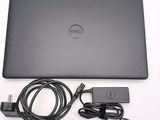 dell laptop computer with power cord and charger sitting on a white surface