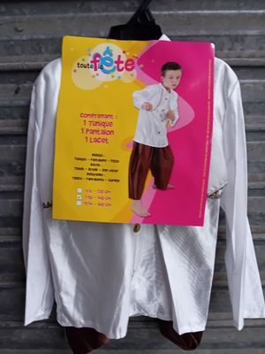 une chemise blanche suspendue à un cintre sur lequel est accrochée une affiche