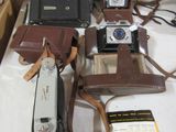 many different types of old cameras on a table