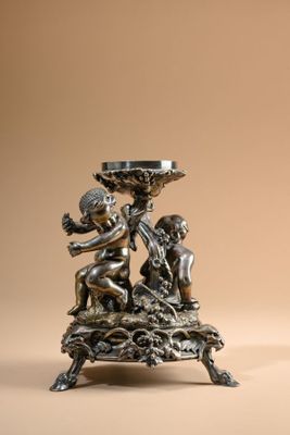 an image of a silver statue of a boy and a girl holding a bowl