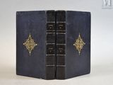 un livre bleu aux bords dorés et à la couverture noire