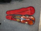 a violin in a case on the floor next to a person