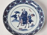 une vieille assiette bleue et blanche représentant un homme chevauchant une chèvre