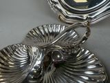 a silver plate with a bird on it on a table