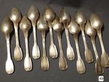 six silver spoons are lined up in a row on a table