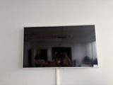 Quelqu'un prend une photo de son reflet dans le miroir d'un téléviseur à écran plat