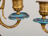 a gold and blue candle holder with two candles on it