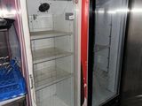 two empty refrigerators in a room with a tile floor