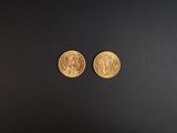 deux pièces d'or posées sur une surface noire