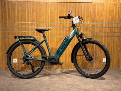 un vélo vert garé dans un garage, à côté d'un mur en bois