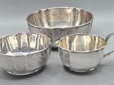 three pieces of silverware on a gray background