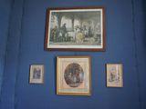des tableaux accrochés au mur d'une pièce bleue où sont accrochés d'autres tableaux