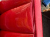 a close up of a red leather chair with a blue cross on it