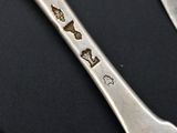 two spoons and a fork on a black table