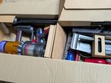 une boîte en carton remplie d'outils divers, posée par terre