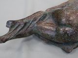 a bronze statue of a woman laying on a pillow