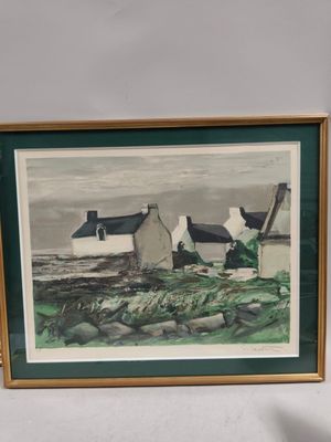 framed picture of a painting of a cottage on the coast