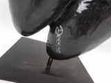 a close up of a black and red sculpture on a black base