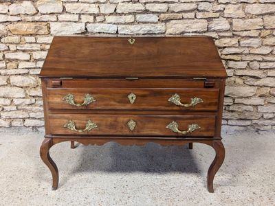 a small wooden chest of drawers on a stand