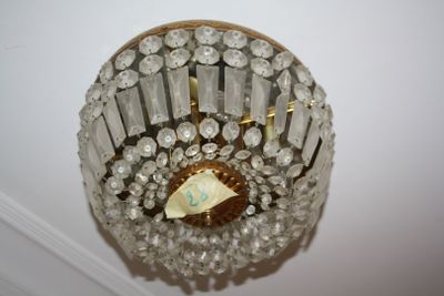 a chandelier hanging from the ceiling with a paper boat in it