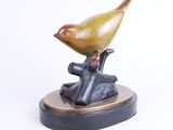 sculpture of a bird perched on a tree branch on a white background