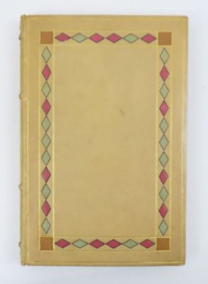 un vieux livre jaune dont la couverture est ornée d'un motif rose et vert