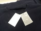 a tag on a black t - shirt that is hanging on a hanger