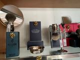a display of shavings, razors, and other items on a glass shelf