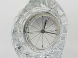 une petite horloge en cristal posée sur une table