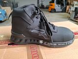 un gros plan sur une paire de chaussures noires posées sur une boîte