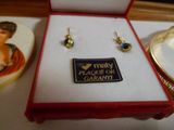 une boîte contenant une paire de boucles d'oreilles et une assiette décorée d'une image