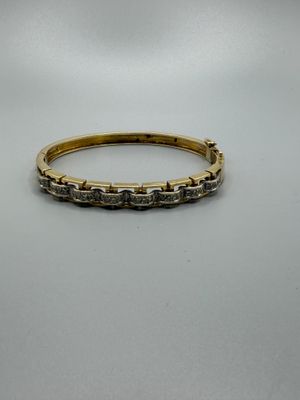 gros plan d'une bague en or et diamants sur une surface blanche