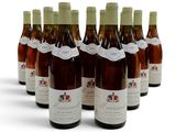 six bouteilles de vin sont alignées sur une surface blanche