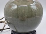 a green vase with a black base on a white background