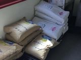 bags of rice sitting on a shelf next to a window