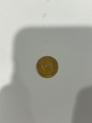 a gold coin sitting on top of a white table
