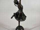 a bronze statue of a girl dancing on a pedestal