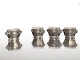 trois vases en argent posés les uns à côté des autres sur une table