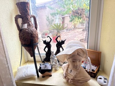 une statue représentant une fillette assise sur le rebord d'une fenêtre