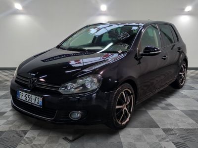 La voiture noire est garée sur le sol à damier du garage.