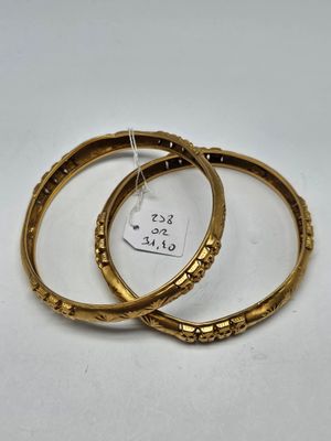 une paire de bracelets en or sur lesquels est accrochée une étiquette de prix