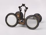 une paire de jumelles anciennes avec une loupe, sur fond blanc
