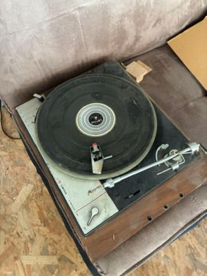 an old record player sitting on top of a suitcase