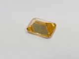 a close up of a yellow diamond on a white surface