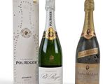 deux bouteilles de champagne et une boîte de vin posées sur une surface blanche