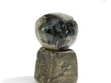 a stone ball sitting on top of a rock