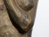bronze statue of a woman holding her hand up to her face
