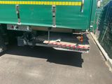 a green and yellow truck parked in a parking lot